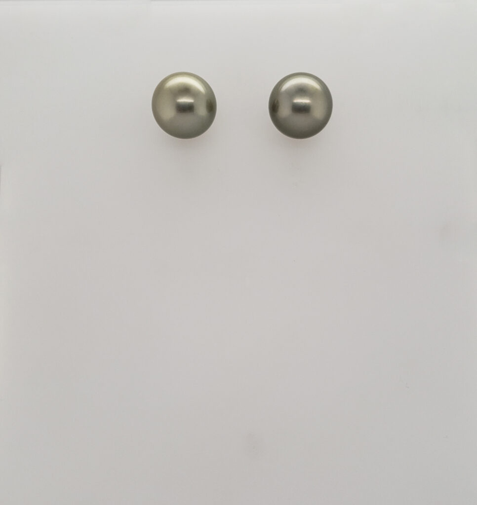 A pair of silver earrings sitting on top of a white surface.